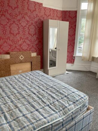 A cozy double bedroom featuring a bright, welco...