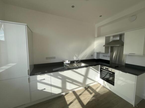 Bright modern kitchen with sleek white cabinetr...