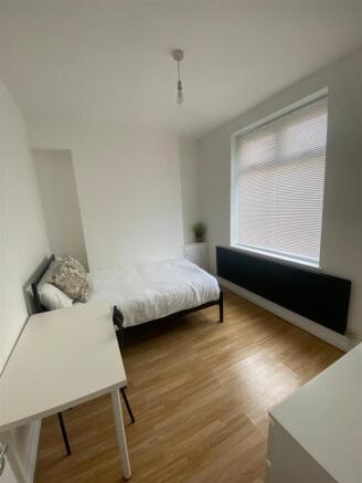Bright bedroom with large window and study desk...