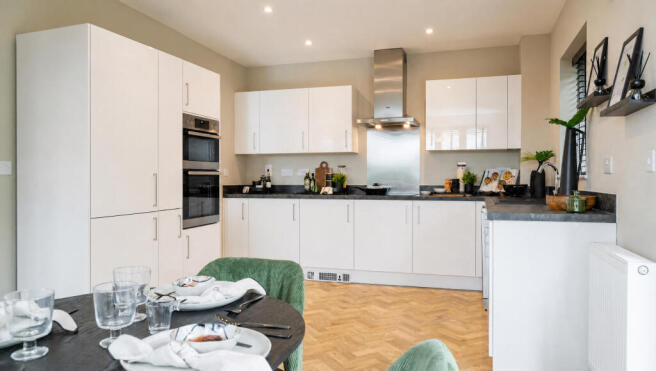 A modern kitchen with white cabinets and stainless steel appliances is visible in the background