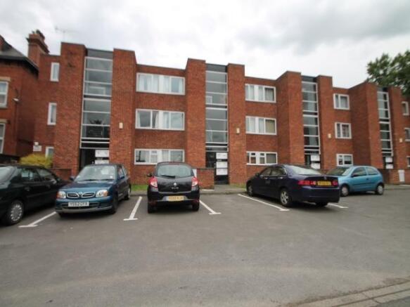 Red-brick apartment building with multiple wind...