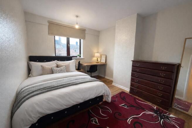 Bright, neatly styled double bedroom with a com...