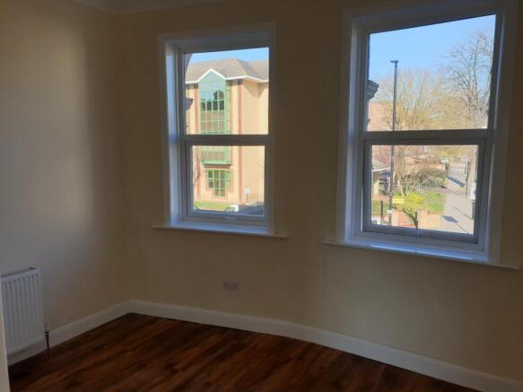 Bright bedroom with large windows and wood floo...