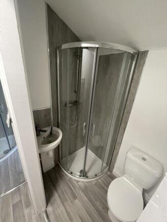 A modern bathroom featuring a curved glass show...
