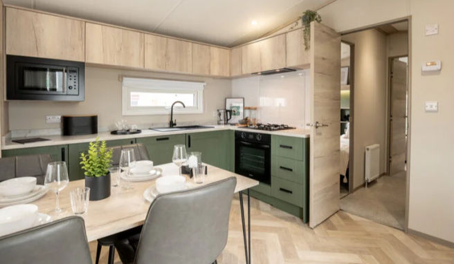 Modern Dining Area And Green Fitted Kitchen In The