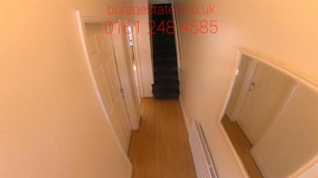 Bright narrow hallway with wall mirror...
