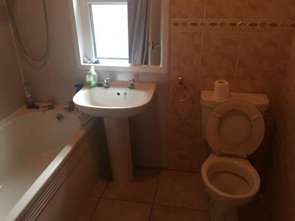 Bright bathroom with bathtub and tiled walls...