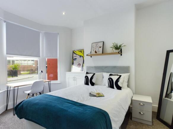 A bright and stylish double bedroom featuring m...