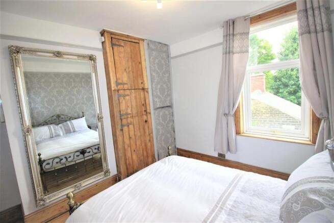 Bright bedroom with characterful storage mirror...