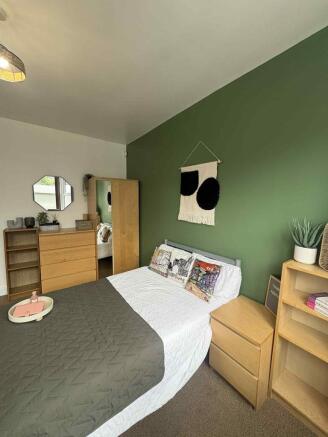 A stylish double bedroom featuring a cozy bed w...