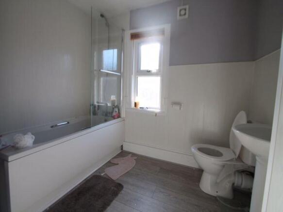 A bright and clean bathroom featuring a full ba...