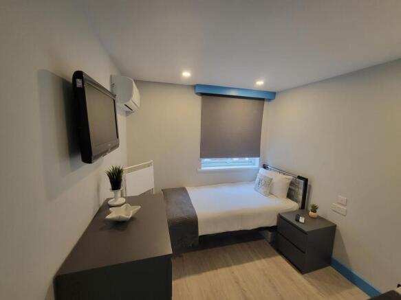 Bright, modern single bedroom with a comfortabl...