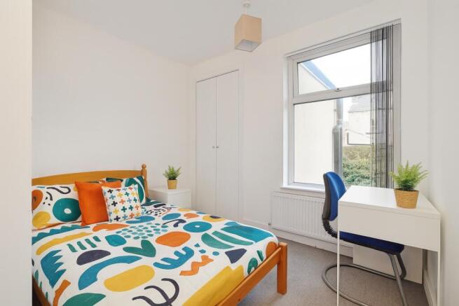 A brightly lit double bedroom featuring a color...
