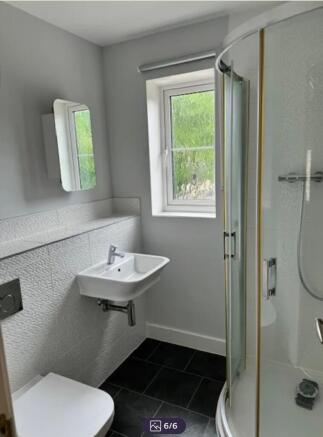 Bright modern bathroom with a corner shower enc...