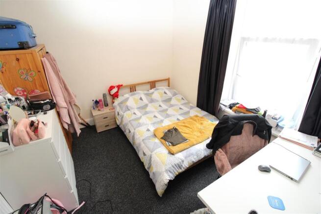 Bright bedroom with large window and study desk...