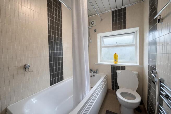 Bright bathroom featuring a full bath and windo...