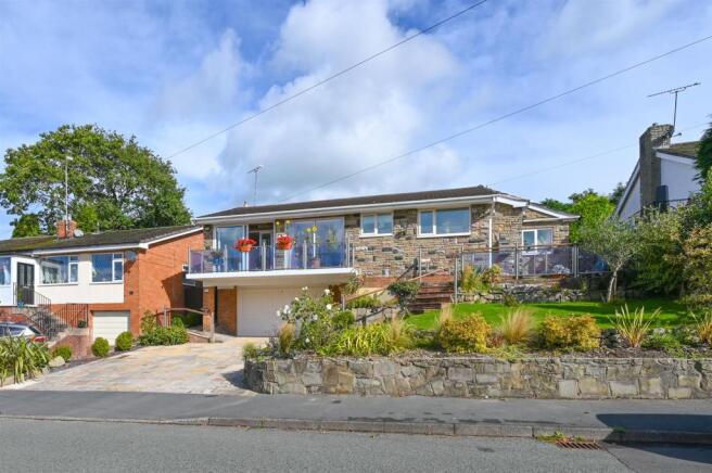 Large driveway and landscaped gardens to front