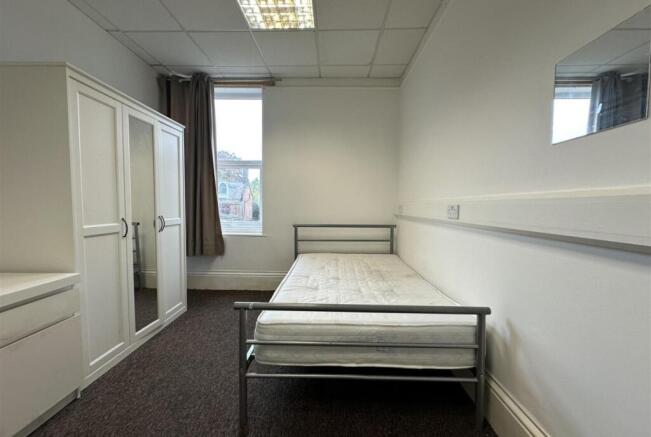 Bright, simply furnished bedroom with a single ...