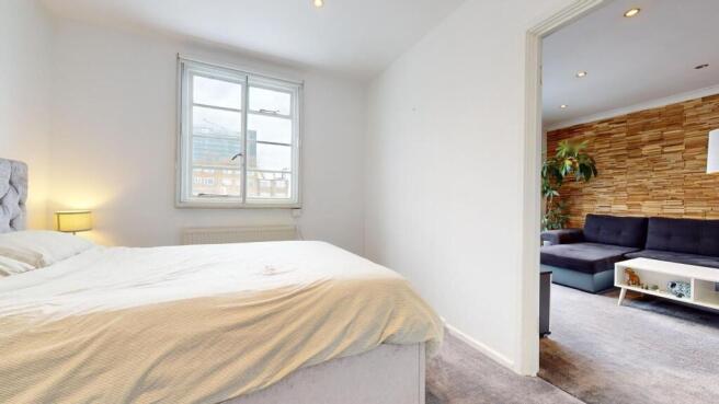 Bright, simply styled double bedroom with a com...