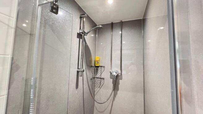 Modern tiled shower with glass enclosure...