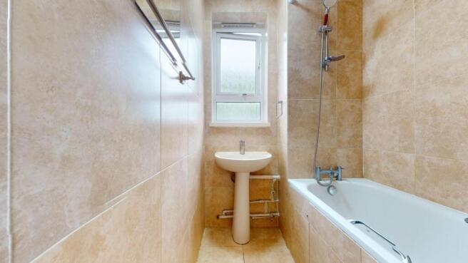 Bright tiled bathroom with a full-sized bath...