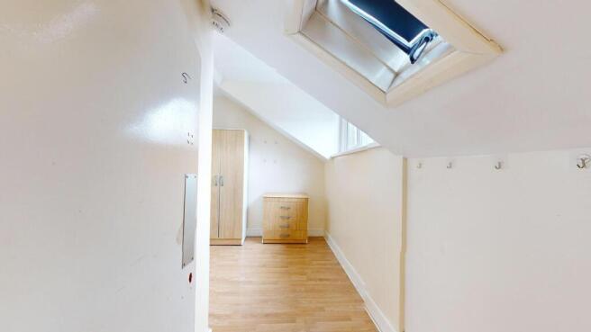 Bright, modern upper-floor hallway with skyligh...
