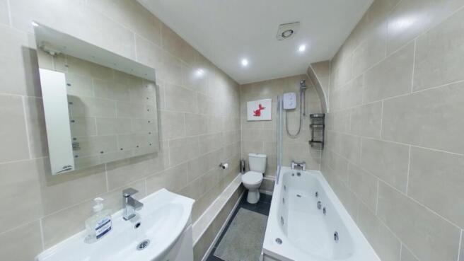 A spacious and well-lit large bathroom featurin...