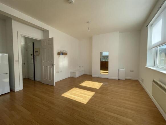 Bright and spacious living area with wood floor...