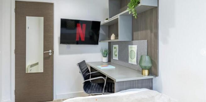 Sleek modern workspace with wall-mounted TV...