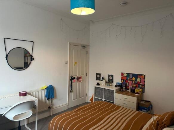 Bright, tidy bedroom with desk and storage...