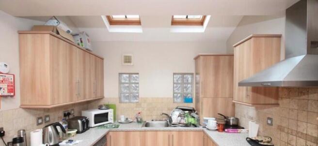 Modern galley-style kitchen with light wood cab...