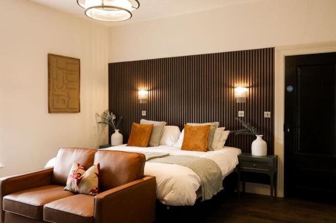 Elegant bedroom with wood paneling and leather ...