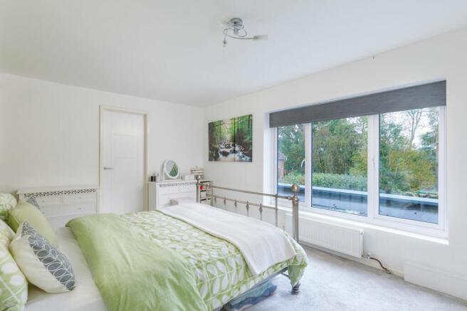 Master bedroom with wonderful views over the garden and woods