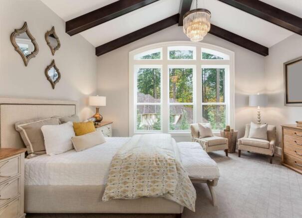 Elegant master bedroom with a large, airy windo...