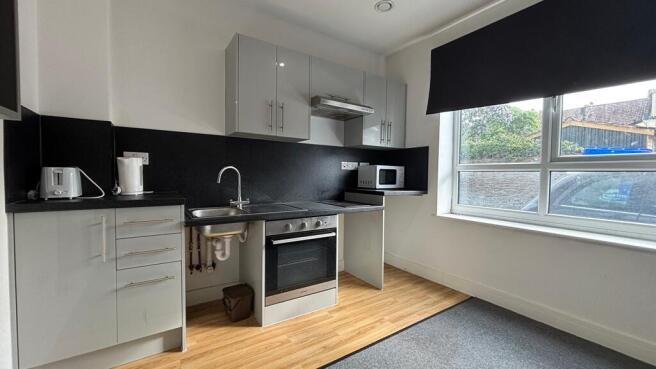 Modern kitchen with sleek grey units and window...
