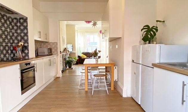 Bright modern galley-style kitchen with white c...