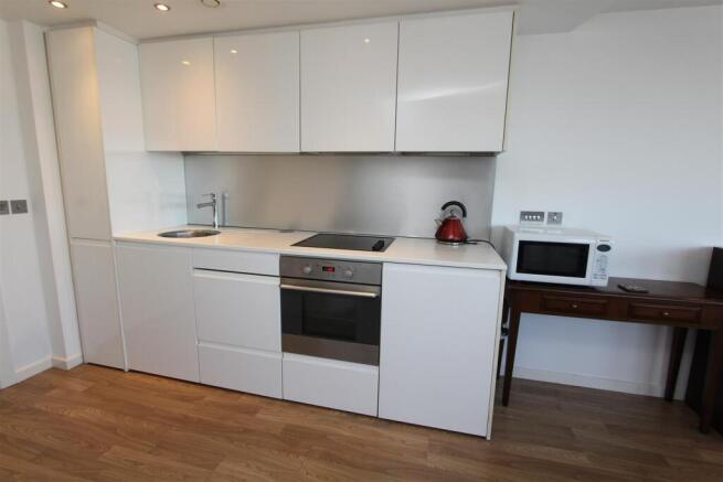 Modern white kitchen with sleek fitted applianc...