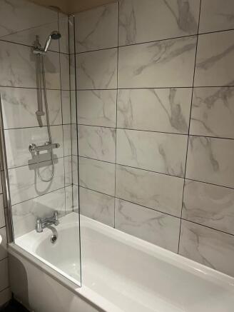 Modern bathroom suite with a clean white bathtu...