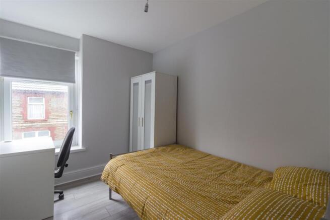 Bright modern bedroom with desk and wardrobe...