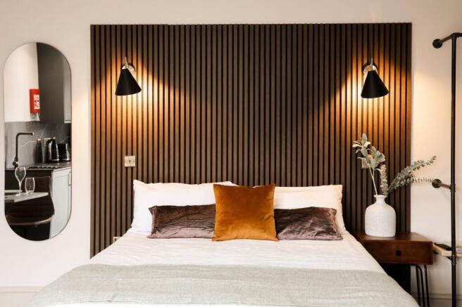 Stylish double bedroom with feature wood paneli...