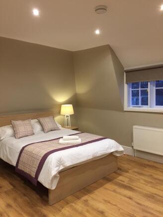 Modern double bedroom with sleek wood flooring...