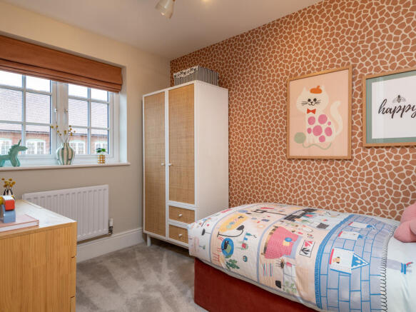 Bedroom 3 interior designed with soft pink and beige tones, featuring a nice sized window for plenty