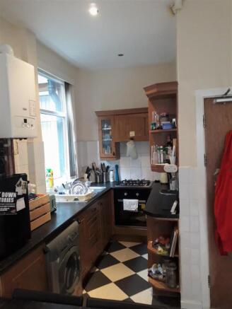 Bright galley-style kitchen with checkerboard f...