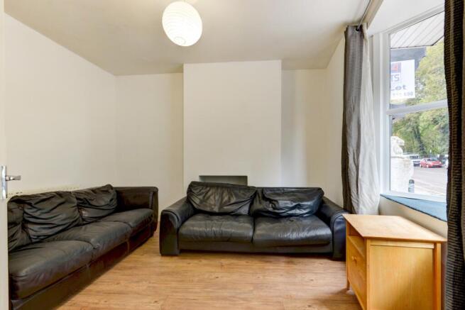 A well-lit, tidy living room featuring two larg...