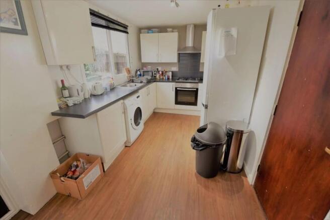 Bright galley-style kitchen with white cabinetr...