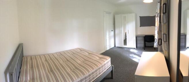 Bright, neutrally decorated bedroom with a doub...