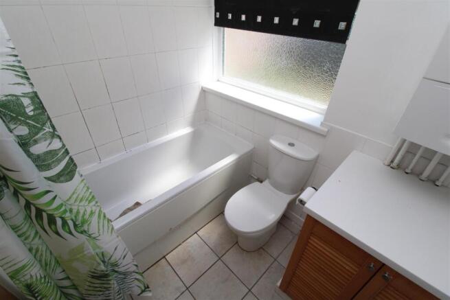Bright bathroom featuring a full bathtub...