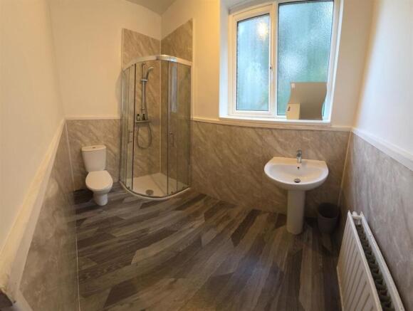 Bright modern bathroom with a corner glass show...