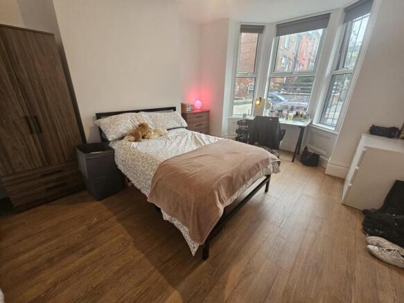 A spacious and well-lit master bedroom featurin...