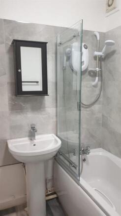 Bright, modern bathroom with a white pedestal s...